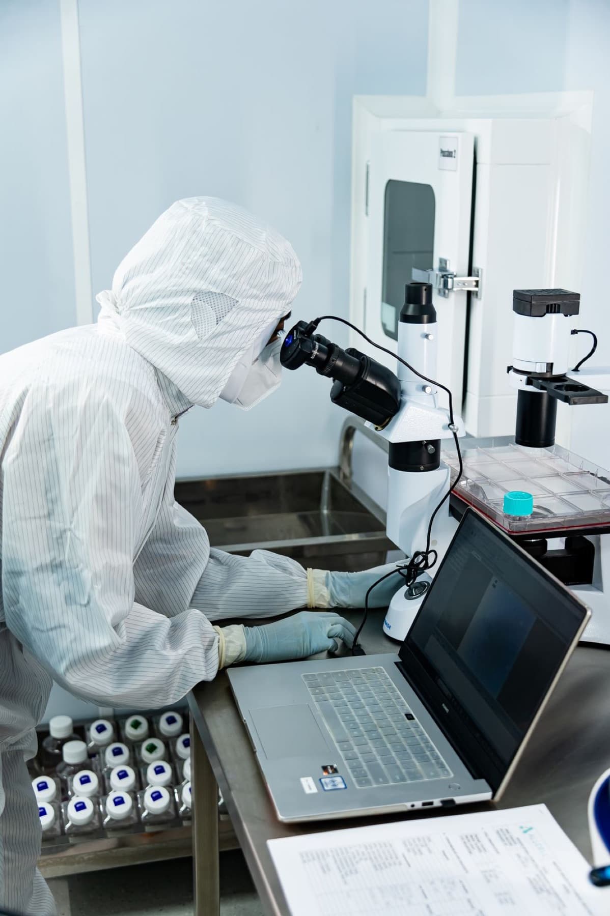 A scientist recording data at the microscope workstation